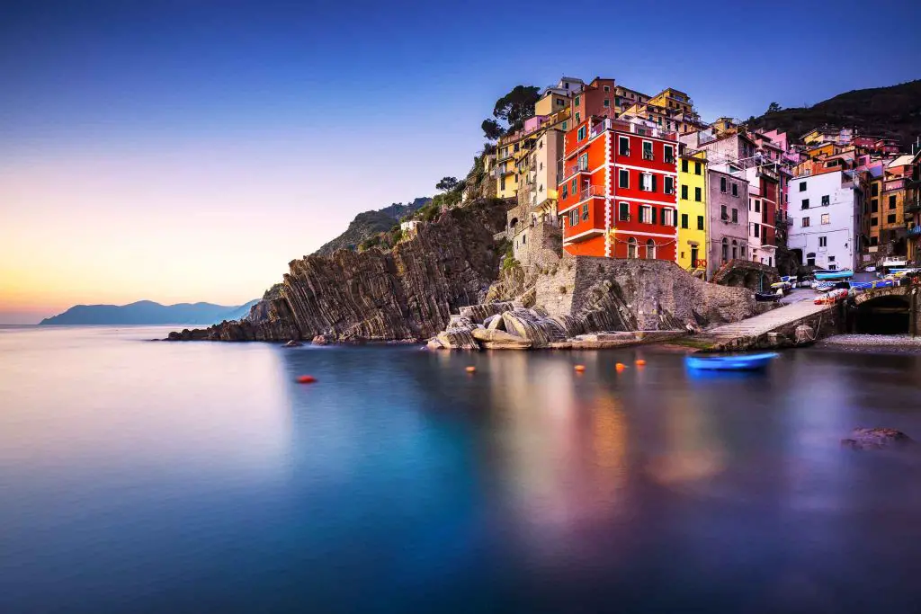 Riomaggiore town, cape and sea landscape at sunset. Cinque Terre